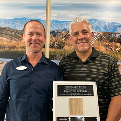 Employee of the month Ed Cardoza, seen here holding a plaque with Executive Director Evan Grannucci